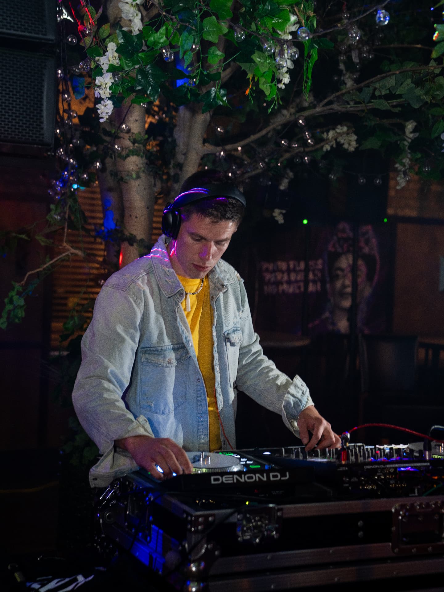 DJ Lalo X playing a set at a wedding reception, wearing headphones behind his decks